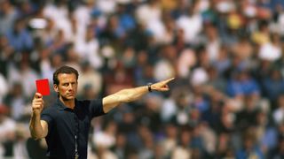 A football referee holding up a red card