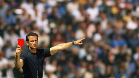 A football referee holding up a red card