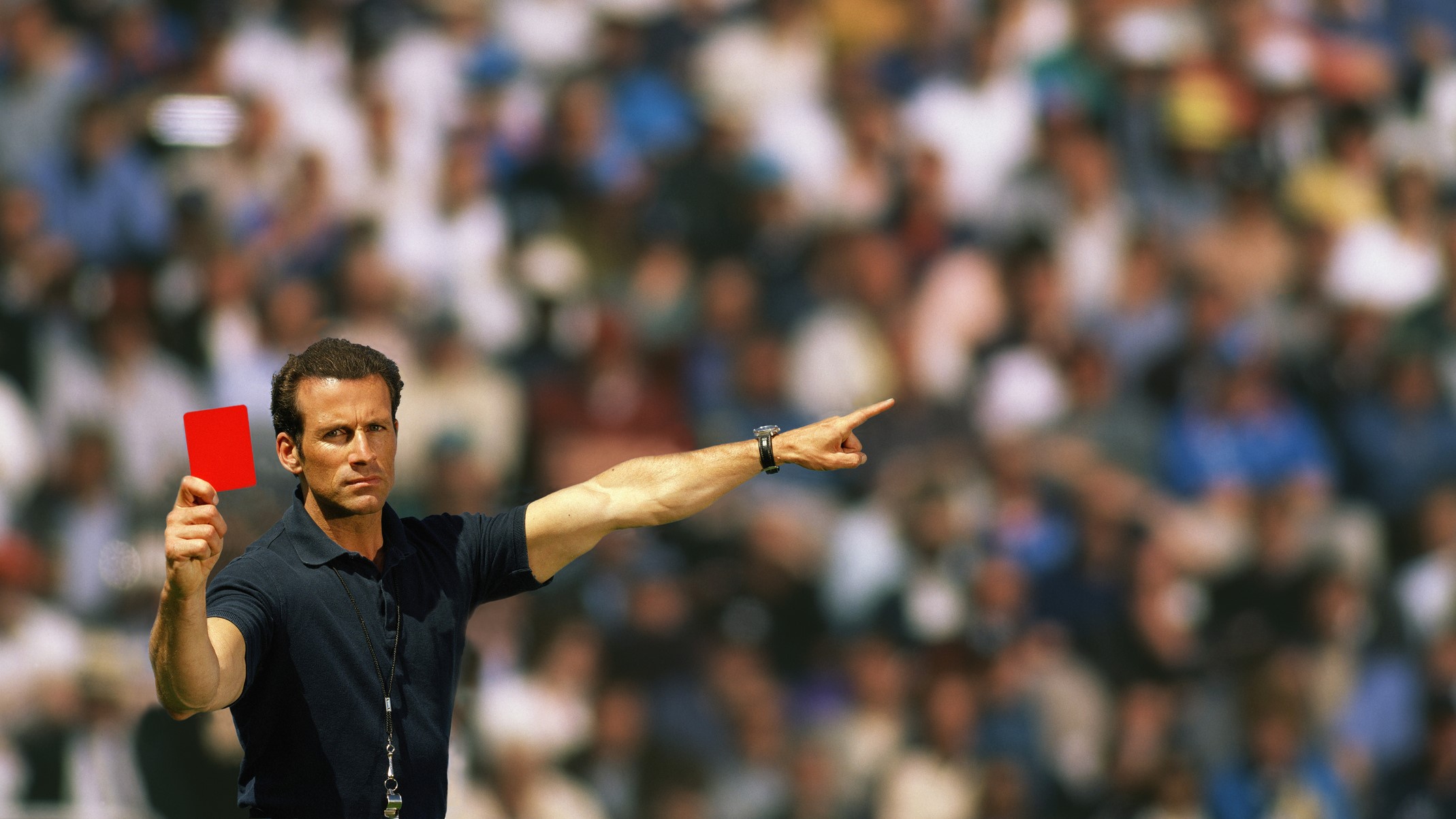 A football referee holding up a red card
